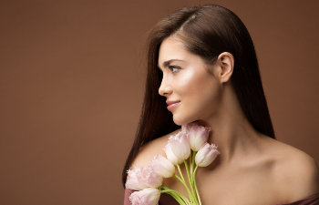 attractive brunette holds a bouque of pink tulips