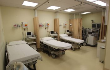 Hospital room with two empty beds and medical equipment.